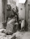 <em>Untitled (Elderly Woman Carrying Jar and Bag),</em>c. 1950s/1960s<br />Gelatin silver print,<br />Image: 11 7/8 x 9"